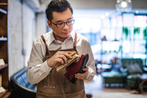 Worker brushing shoe in shoe store 