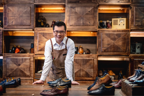 Worker leaning against table in shoe store